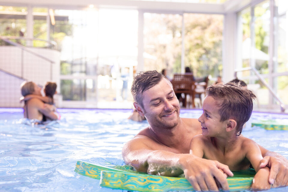Father and son enjoying the indoor heated pool, making Commodore preferred family accommodation in Christchurch